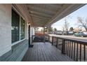 Spacious covered front porch with wood railing and outdoor lighting at 795 Troy Ct, Aurora, CO 80011