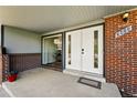 Inviting entryway with double doors and brick accents, leading into a cozy home at 7413 S Tamarac St, Centennial, CO 80112