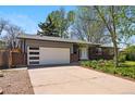 Brick home boasts a spacious driveway leading to an attached garage, complemented by a beautifully maintained front lawn at 7413 S Tamarac St, Centennial, CO 80112