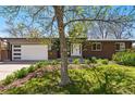Lovely home featuring a brick facade, lush lawn, and attached garage, blending curb appeal with functionality at 7413 S Tamarac St, Centennial, CO 80112