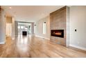 Spacious living room with hardwood floors, a modern fireplace, and natural light at 3122 Perry St, Denver, CO 80212