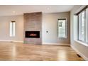 Open living room with a modern fireplace and light hardwood floors, enhanced by natural light at 3122 Perry St, Denver, CO 80212