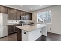 Modern kitchen features stainless steel appliances, granite countertops, and dark wood cabinets at 9250 Rifle St, Commerce City, CO 80022