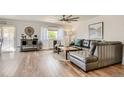Spacious living room with hardwood floors, large sofa, and an oversized ceiling fan at 6069 S Marshall Dr, Littleton, CO 80123
