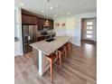 Modern kitchen boasts a large island with granite countertops, seating, and stainless appliances at 3029 Merlin Dr, Brighton, CO 80601