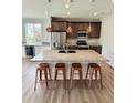 Modern kitchen boasts a large island with granite countertops and stainless steel appliances at 3029 Merlin Dr, Brighton, CO 80601