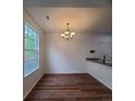 Open dining room with modern lighting, wood floors, and large windows with lots of natural light at 8802 E 24Th Pl # 101, Denver, CO 80238