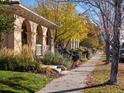 Street view of a home with manicured landscaping and mature trees lining the sidewalk at 8985 E 29Th Pl, Denver, CO 80238