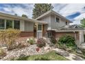 Close up of the front entrance with beautiful landscaping, brick accents, and a well-maintained lawn at 6211 S Garfield Dr, Centennial, CO 80121