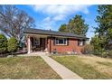 Charming brick home with covered porch and well-maintained lawn at 2527 S Vine St, Denver, CO 80210