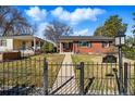 Charming brick home with black fence and well-kept lawn at 2527 S Vine St, Denver, CO 80210