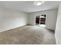 Bright living room with carpet and sliding glass door at 8019 Wolff St # H, Westminster, CO 80031