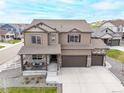 Stunning aerial view of a two-story home with a large driveway and a beautifully landscaped yard at 2040 Rosette Pl, Castle Rock, CO 80104
