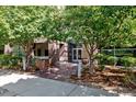 Condo building brick entryway featuring glass doors and well-maintained landscaping at 2958 Syracuse St # 214, Denver, CO 80238