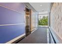 Hallway featuring an elevator, carpet runner, and large window providing natural light at 2958 Syracuse St # 214, Denver, CO 80238