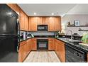 Well-equipped kitchen with wooden cabinets, black appliances, and ample counter space at 975 N Lincoln St # 12J, Denver, CO 80203