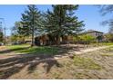 View of a charming home's front yard with trees, landscaping, and a fence at 2000 S Columbine St, Denver, CO 80210