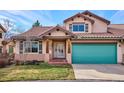 Tan two-story home with a teal garage door and landscaping at 1060 Cottonwood Cir, Golden, CO 80401