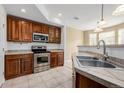 Well-equipped kitchen featuring wooden cabinets, stainless steel appliances, and a tiled countertop at 9461 Elmhurst Ln # C, Highlands Ranch, CO 80129