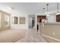 Bright and open-concept living area with tiled flooring, neutral walls, and a staircase view at 9461 Elmhurst Ln # C, Highlands Ranch, CO 80129