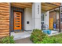 Inviting front porch with modern details, orange door, and a cozy seating area at 3632 N Pecos St, Denver, CO 80211