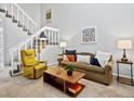 Inviting living room featuring plush seating, stylish coffee table, modern decor, and a staircase at 2862 S Vaughn Way, Aurora, CO 80014