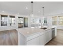 Open-concept kitchen with stainless steel appliances, white cabinetry, quartz countertops, and a view of the balcony at 928 Farrier Ln, Lafayette, CO 80026