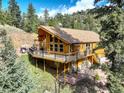 Stunning view of home with a spacious wrap-around deck, ideal for entertaining guests at 1353 Elk Valley Dr, Evergreen, CO 80439