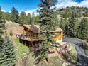 Beautiful mountain home with multiple outdoor areas and a stone-terraced yard at 1353 Elk Valley Dr, Evergreen, CO 80439