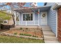 Inviting front porch with white railing, flower bed, steps leading to the front door with a decorative wreath at 11402 Benton Ct, Westminster, CO 80020