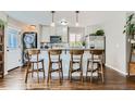 Modern kitchen featuring a breakfast bar with four chairs and stainless steel appliances at 1171 Syracuse St, Denver, CO 80220