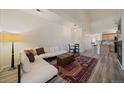 Cozy living room area with bright light, a large sofa, and wood-look flooring at 5465 Zephyr St # 201, Arvada, CO 80002