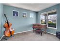 Cozy living room with natural light, a piano and cello, offering an inviting space for relaxation or musical pursuits at 428 Starline Ave, Lafayette, CO 80026