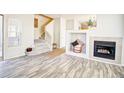 Inviting living room with a cozy fireplace, neutral decor, and modern gray wood floors at 13033 Grant E Cir # B, Thornton, CO 80241