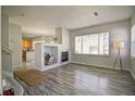 Bright living room with a fireplace, large windows, and open layout leading into the kitchen at 13033 Grant E Cir # B, Thornton, CO 80241