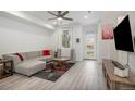 Bright living room with L-shaped sectional sofa and hardwood floors at 24257 E 41St Ave, Aurora, CO 80019