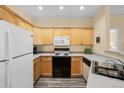 Kitchen with white appliances, and light wood cabinets at 7459 S Alkire St # 202, Littleton, CO 80127