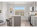 Modern kitchen area featuring a large window, stainless steel appliances and quartz countertops at 2140 Santini Trl # F, Littleton, CO 80129