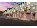Townhomes with pink doors and brown balconies complement the colorful sunset at 2951 W Riverwalk Cir # N, Littleton, CO 80123