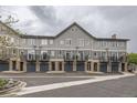 Row of gray townhomes with individual garages and balconies on a cloudy day at 2951 W Riverwalk Cir # N, Littleton, CO 80123