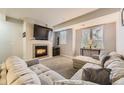 Cozy living room featuring a fireplace, large sectional sofa, and a bright window at 2951 W Riverwalk Cir # N, Littleton, CO 80123