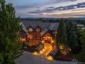 Exterior shot of landscaped luxury home, featuring a stone and brick facade, and a colorful slate roof at 4030 E Forbes Ct, Greenwood Village, CO 80121