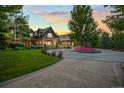 An amazing estate featuring lush lawns, colorful landscaping, and a circular driveway at 4030 E Forbes Ct, Greenwood Village, CO 80121