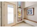 Bright entryway with frosted glass door and bench at 680 Crescent Ln, Lakewood, CO 80214
