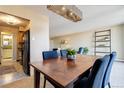 Cozy dining area featuring a wooden table with chairs, a modern light fixture, and views into the living room at 955 Eudora St # 708E, Denver, CO 80220