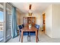 Bright dining area with a wooden table, blue chairs, built-in hutch, and a sliding door for balcony access at 955 Eudora St # 708E, Denver, CO 80220