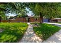 Beautiful brick home on a verdant lawn, with mature trees providing shade and curb appeal at 6572 E Dakota Ave, Denver, CO 80224