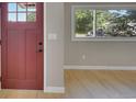 Inviting entryway features a classic maroon front door and seamless access to the naturally lit main living area at 1596 S Stuart St, Denver, CO 80219