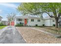 Well-kept single-story home showcasing the front yard, charming curb appeal, and orange front door at 5115 Bryant St, Denver, CO 80221