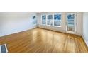 Sunlit living room featuring pristine hardwood floors, white walls, and large windows for ample natural light at 9486 E 107Th Ave, Commerce City, CO 80640